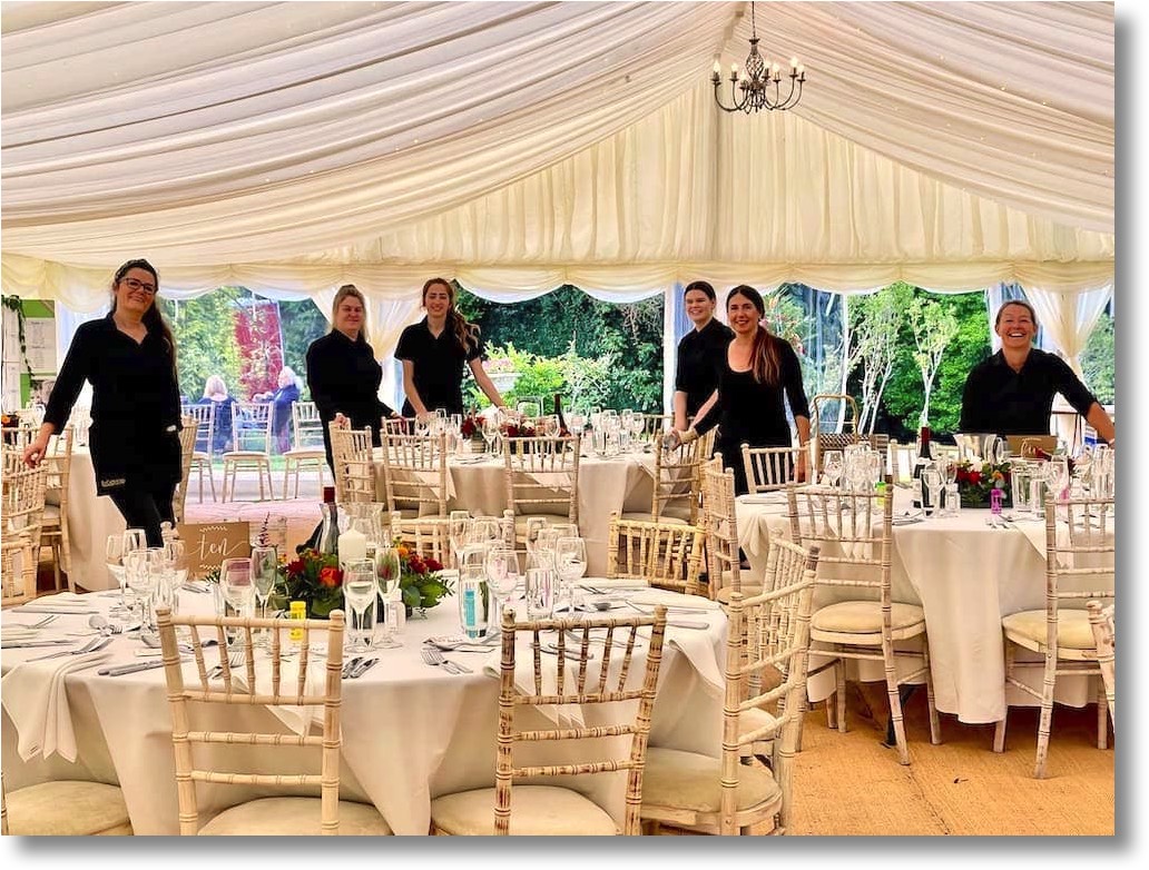 EpiCatering Waitsaff inside a marquee that is fully set up for a wedding reception