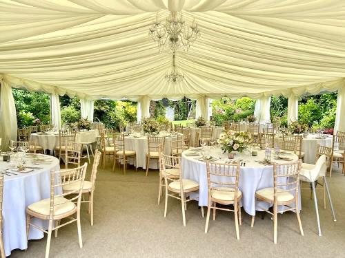 Inside a lined marquee with tables dressed and ready for the wedding guests.