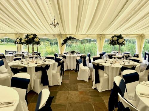 Inside Milwards Estate's wedding marquee with tables dressed up for the wedding reception
