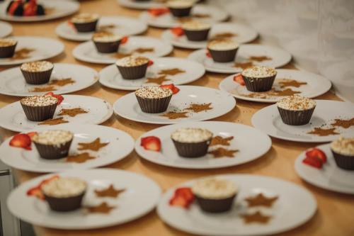 Plates of desserts with cheesecake filled dark chocolate cups, in the middle of being prepared for service.