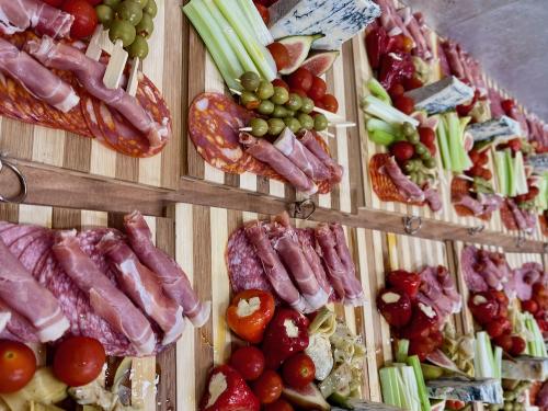 Bamboo boards with mixed charcuterie, olives, artichoke hearts, Gorgonzola cheese, stuffed peppers and celery sticks.